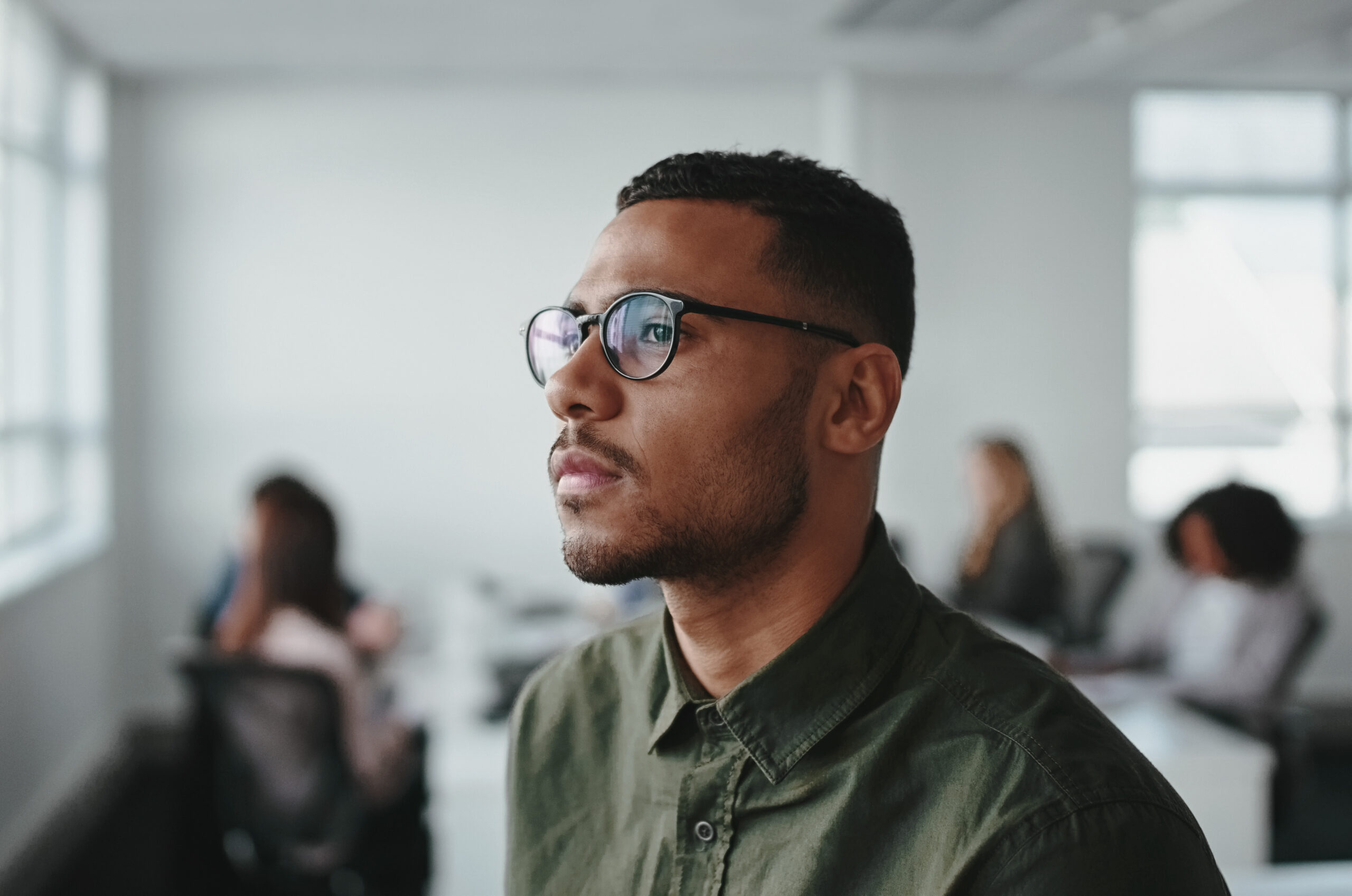 Thoughtful young businessman looking away at office