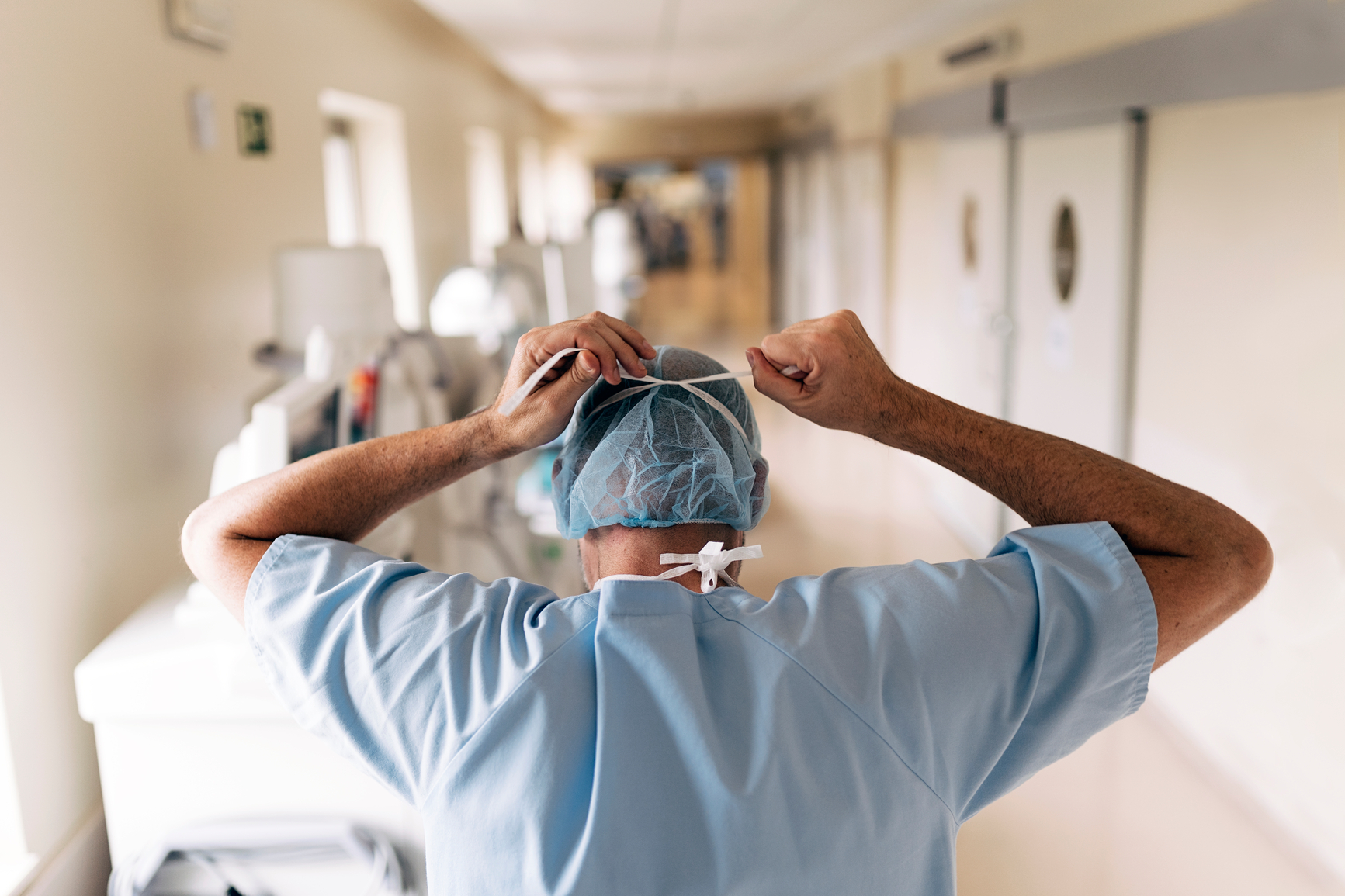 Unrecognizable doctor covering his face with mask in hospital. Medical concept.